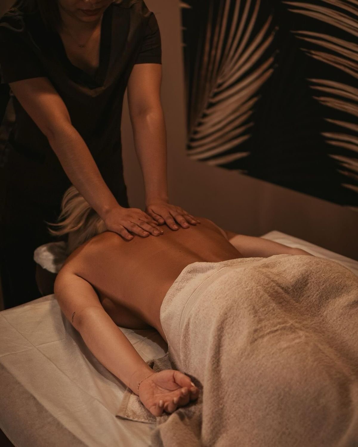 Terapeuta aplicando un masaje de espalda con luz cálida